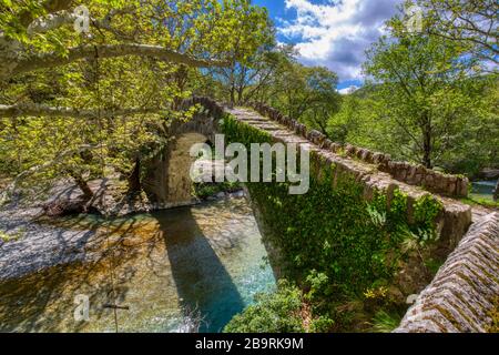 Alte Steinbrücke in Klidonia Zagori, Epirus, Westgriechenland. Diese Bogenbrücke mit verlängertem Bogen, die im Jahr 1853 erbaut wurde. Stockfoto