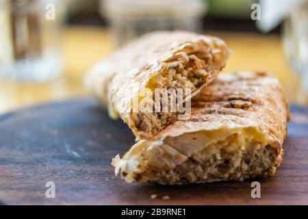 Gesundes Tuna Fisch-Wrap auf Holzbrett im Restaurant. Organische Lebensmittel. Stockfoto