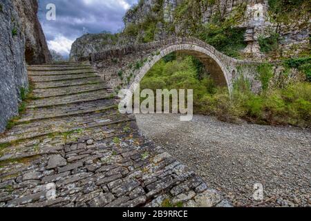 Kokori alten Bogen Steinbrücke (noutsos) auf dem Fluss Voidomatis in der Gemeinde Zagorochoria, Griechenland. Stockfoto