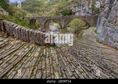 Kokori alten Bogen Steinbrücke (noutsos) auf dem Fluss Voidomatis in der Gemeinde Zagorochoria, Griechenland. Stockfoto