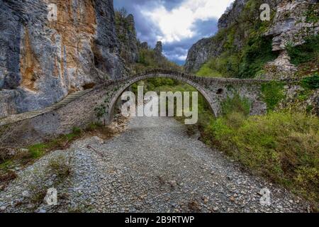 Kokori alten Bogen Steinbrücke (noutsos) auf dem Fluss Voidomatis in der Gemeinde Zagorochoria, Griechenland. Stockfoto