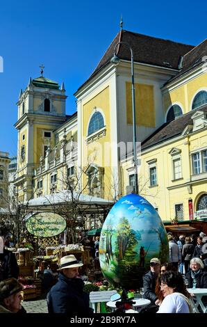 Wien, Österreich - 27. März 2016: Nicht identifizierte Personen und Arful dekoriert Riesen Osterei auf traditionellen Ostermarkt auf der Freyung Platz mit Kirche Stockfoto