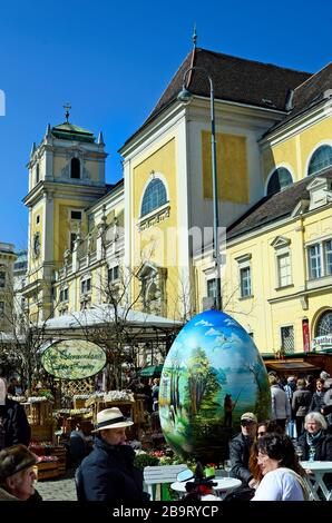 Wien, Österreich - 27. März 2016: Nicht identifizierte Personen und Arful dekoriert Riesen Osterei auf traditionellen Ostermarkt auf der Freyung Platz mit Kirche Stockfoto