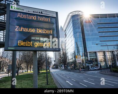 25. März 2020, Hessen, Frankfurt am Main: Ein Schild auf der breiten Straße, die am Messegelände vorbei in die Stadt führt, rät "Distanz halten! Bleiben Sie zu Hause! Bleib gesund!". Foto: Frank Rumpenhorst / dpa Stockfoto