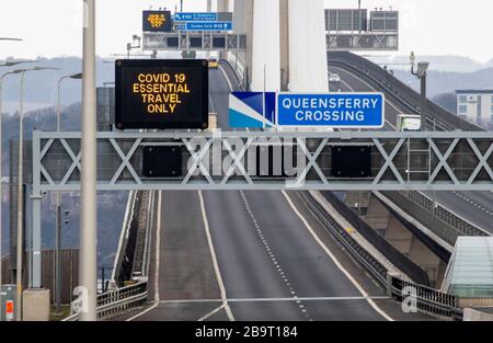 Hinweisschilder weisen darauf hin, dass die Menschen nur auf dem Queensferry Crossing in der Nähe von Edinburgh wichtige Reisen Unternehmen müssen, nachdem Premierminister Boris Johnson Großbritannien in Sperrstellung versetzt hat, um die Ausbreitung des Coronavirus einzudämmen. Stockfoto