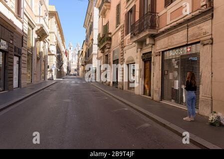 ROM, ITALIEN - 12. März 2020: Eine Frau steht vor geschlossenen Geschäften in der Via dei Condotti, neben der spanischen Treppe, Rom, Italien. Man muss die rechtfertigen Stockfoto