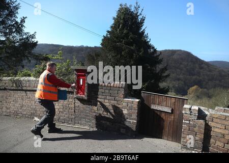 Der Postzusteller Matt liefert Post im Dorf Ironbridge in Shropshire, während seine Kunden zu Hause bleiben müssen, nachdem Premierminister Boris Johnson Großbritannien in Sperrstellung versetzt hat, um die Ausbreitung des Coronavirus einzudämmen. Stockfoto