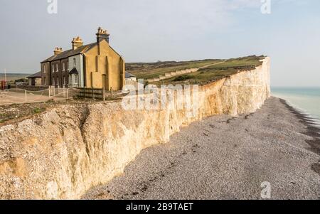 Küstenerosion, Sussex, Großbritannien. Eine abnehmende Reihe von Reihenhäusern, die die Auswirkungen des Wetters auf die Kreidefelsen im Süden Englands zeigen. Stockfoto