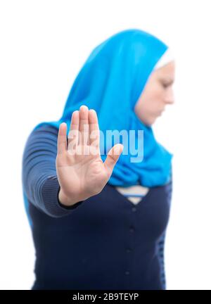 Nahaufnahme des Porträts einer ernsthaften jungen muslimischen Frau, die mit ihrer Handfläche, die über weißem Hintergrund isoliert ist, eine Geste der Stoppverweigerung zeigt Stockfoto