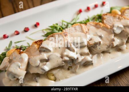 Huhn auf geriebenem Gnocchi in Sahnesauce aus Pilzen und Räucherkäse auf dem Tisch Stockfoto