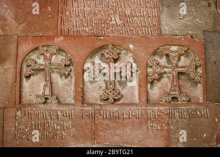 Drei verschiedene Armenierkreuze schnitzen an der Steinfassade der Armenisch-orthodoxen Kirche Stockfoto