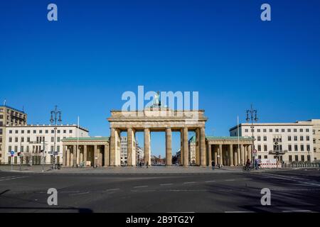 23.03.2020, das Brandenburger Ziel in Berlin an einem späten Frühlingssaftstag in der tiefen Sonne. Wegen der Koronakrise sind in Berlin nur wenige Menschen auf den Straßen und Plätzen. Weltweite Verwendung Stockfoto