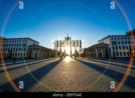 23.03.2020, das Brandenburger Ziel in Berlin an einem späten Frühlingssaftstag in der tiefen Sonne. Die Sonne scheint durch die Prophylaxe und erzeugt eine besondere Licht- und Schattenstimmung. Wegen der Koronakrise sind in Berlin nur wenige Menschen auf den Straßen und Plätzen. Weltweite Verwendung Stockfoto