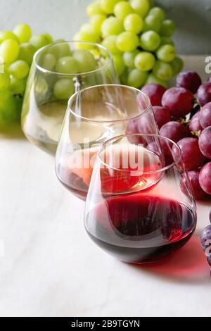 Vielzahl von Wein. Rotwein, Rosé und Weißwein in Old Fashion Brille mit Trauben auf weißem Marmor tisch Stockfoto