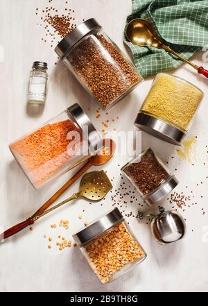 Glasgefäße mit Hülsenfrüchten, Groschen und nützlichen Samen. Gesundes vegetarisches Essen. Sauberes Esskonzept, Draufsicht Stockfoto