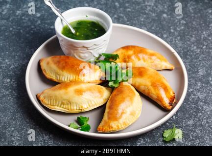 Empanadas mit Schimichurri Sauce. Traditionelle lateinamerikanische Küche. Stockfoto