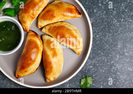 Empanadas mit Schimichurri Sauce. Traditionelle lateinamerikanische Küche. Draufsicht, Kopierbereich Stockfoto