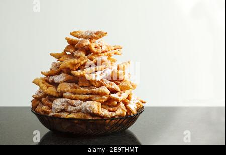 Krapfen mit Puderzucker bestäubt. Frappe oder CHIACCHIERE. Traditionelle italienische und russische Karneval Essen Stockfoto