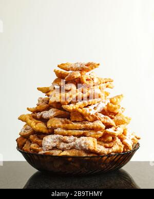 Krapfen mit Puderzucker bestäubt. Frappe oder CHIACCHIERE. Traditionelle italienische und russische Karneval Essen Stockfoto