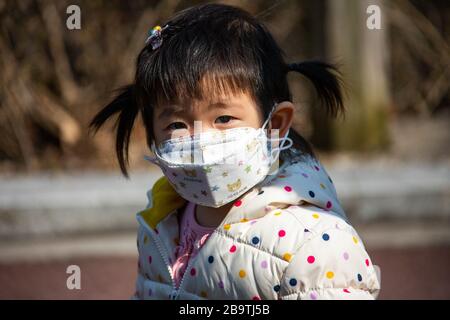 Junge Mädchen, die während der Coronavirus Pandemie in Seoul, Südkorea, Asien eine schützende Gesichtsmaske tragen Stockfoto