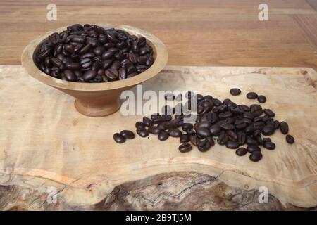 Sumatra Mandheling Kaffeebohnen in einer Holzschale und breitete sich vor ihr aus. Stockfoto