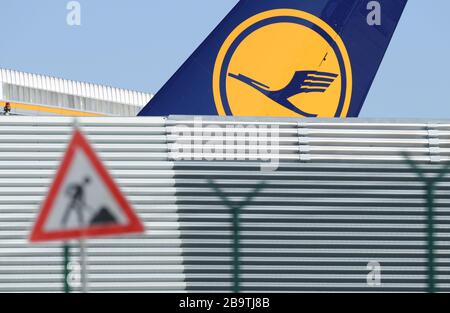 23. März 2020, Hessen, Frankfurt am Main: Hinter einer Blechwand am Frankfurter Flughafen steht ein Passagierflugzeug der Lufthansa, vor dem ein Baustellenschild aufgestellt wurde. Foto: Arne Dedert / dpa Stockfoto