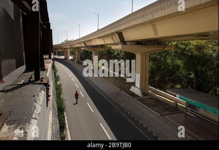 (200325) - Neu DELHI, 25. März 2020 (Xinhua) - ein Mann läuft auf einer leeren Straße während der Sperrung in Neu-Delhi, Indien, 25. März 2020. Am Mittwoch begann die indische Regierung die 21-tägige Sperre im ganzen Land, um den Ausbruch des neuartigen Coronavirus einzudämmen. Alle Straßen-, Schienen- und Luftverkehrsdienste bleiben während der Sperrzeit, die am frühen Mittwoch in Kraft trat, ausgesetzt. Wesentliche Dienstleistungen wurden jedoch von der Sperrung ausgenommen. Unterdessen stieg die Zahl der bestätigten COVID-19-Fälle am Mittwochmorgen in Indien auf 562. Bisher wurden neun Todesfälle im Zusammenhang mit COVID-19 gemeldet Stockfoto