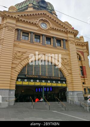 Melbourne, Australien. März 2020. Das mobile Foto zeigt einen Mann, der vor der Flinders Street Station in Melbourne, Australien, am 25. März 2020 sitzt. Ab 15:00 Uhr Ortszeit am Mittwoch gibt es laut Gesundheitsministerium des Landes 2.423 bestätigte Fälle von COVID-19 in Australien. Credit: Gui Qing/Xinhua/Alamy Live News Stockfoto