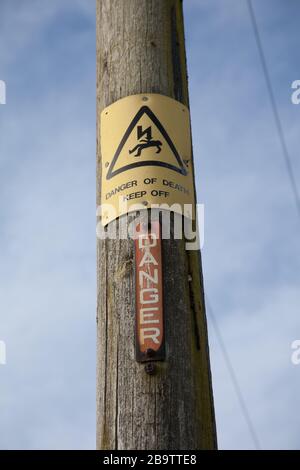 Ein Gefahrschild auf einem elektrischen Pylon fernhalten Stockfoto