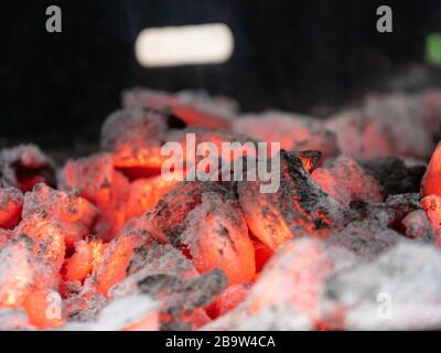 Nahaufnahme von Holzkohle, die im Grillgrill oder Kamin flammlos verbrennt. Stockfoto