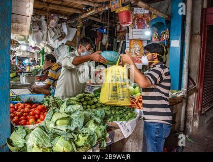 Kolkata, Indien. März 2020. Die Menschen in Kalkutta sind damit beschäftigt, den täglichen Bedarf mit Vorkehrungen in der vorgegebenen Zeit auf verschiedenen Märkten zu erwerben. Premierminister Narendra Modi kündigte gestern eine vollständige Sperre an, die in Indien ab 24. März Mitternacht aufgrund der Zunahme positiver Fälle des neuartigen Corona-Virus im Land beginnt. (Foto von Amlan Biswas/Pacific Press) Credit: Pacific Press Agency/Alamy Live News Stockfoto