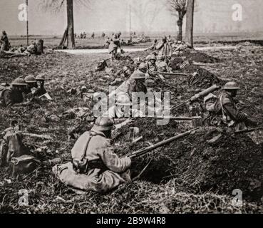 Britische und französische Truppen in Gewehrgruben, die eine Straße in der Nähe von Nesle während der Operation Michael bedeckten, die die deutsche Frühjahrsoffensive am 21. März 1918 begann. Sie wurde von der Hindenburg-Linie in der Nähe von Saint-Quentin in der Nähe von Cambrai, Frankreich, gestartet. Ihr Ziel war es, die Linien der Alliierten (Entente) zu durchbrechen und in nordwestlicher Richtung vorzurücken, um die Kanalhäfen zu beschlagnahmen, die die British Expeditionary Force (BEF) versorgten und die BEF ins Meer trieben. Stockfoto