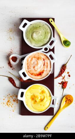 Vegane Mandeln Mayonnaise mit Wasabi, Chili und Kurkuma. Milch-, Ei- und sojafrei. Draufsicht. Stockfoto