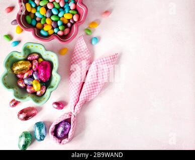 Serviette Osterhase, Dekoration und Eier Ostern Süßigkeiten auf rosa Hintergrund, kopieren Raum Stockfoto