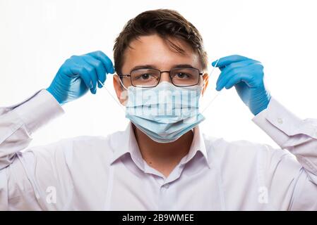 Corona Virus Kovid 19: Nahaufnahme mit dem Gesicht eines jungen Arztes mit Brille und tragen einer medizinischen oder chirurgischen Maske Stockfoto