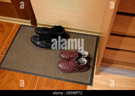 Zwei Paar Schuhe auf einer Türmatte. Schuhe im Flur. Tragekomfort zu Hause. Stockfoto