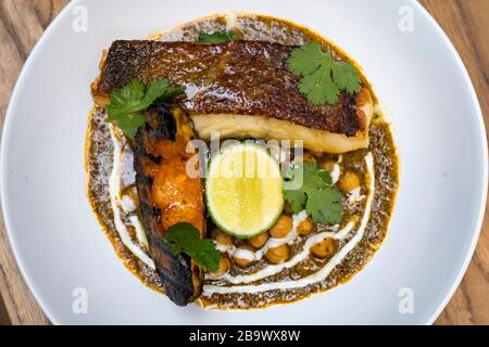 Braten Sie Curry-Kabeljau, delica-kürbis und Kichererbsenmasala Stockfoto