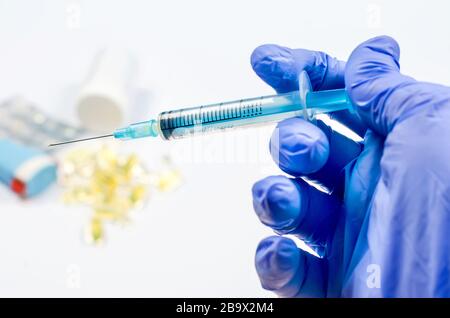 Hand in Handschuhe mit Spritze Pharmazeutische Medizin Konzept, Kopierraum Mockup, flach gelegt. Apothekenthema, Behandlungsmedikation. Stockfoto