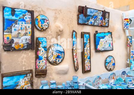 Santorini, Griechenland - 26. April 2019: Straßenmauer des Dorfes Oia mit traditionellen Bildern im Souvenirladen Stockfoto