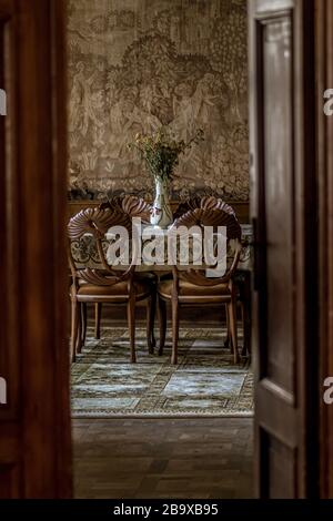 Vertikales Bild eines luxuriösen Speisesaals mit verzierten Stühlen Wie durch eine offene Tür gesehen Stockfoto