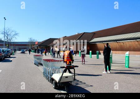 Kunden beobachten soziale Distanzierungen aufgrund des Corona-Virus, während sie in Sainsbury's Harringay haringey Store london england UK Schlange stehen Stockfoto