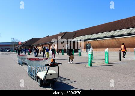 Kunden beobachten soziale Distanzierungen aufgrund des Corona-Virus, während sie in Sainsbury's Harringay haringey Store london england UK Schlange stehen Stockfoto