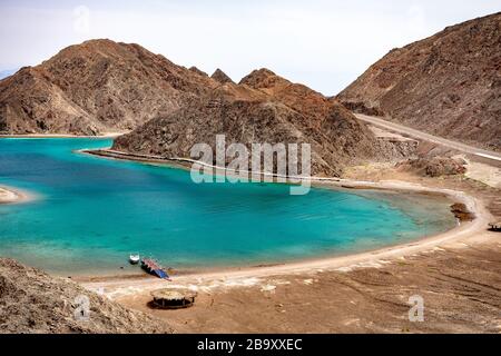 Schöner Panoramablick auf die Fjord Bay Taba im Golf von Akaba, Ägypten. Türkisfarbenes klares Wasser des Roten Meeres und felsige Berge. Stockfoto