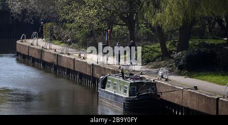 Die Menschen laufen entlang des Kanals im Riverside Park, Newark-on-Trent, nachdem Premierminister Boris Johnson Großbritannien in Sperrstellung versetzt hat, um die Ausbreitung des Coronavirus einzudämmen. Stockfoto