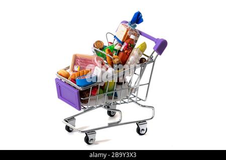 Miniatur-Einkaufswagen voll mit Waren isoliert auf weißem Hintergrund. Stockfoto