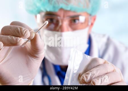 Medizinische Person mit individuellen Schutzelementen, die eine orale Probe zur Analyse mit einem Wattestäbchen nimmt. Stockfoto