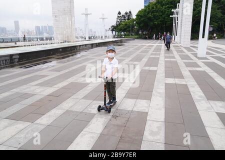 Hongkong, China. März 2020. Ein Kind fährt mit einem Roller in Sai WAN in Hongkong, Südchina, 25. März 2020. Die Menschen in Hongkong nehmen an verschiedenen Übungen im Rahmen der COVID-19-Epidemie Teil. Credit: Lui Siu Wai/Xinhua/Alamy Live News Stockfoto