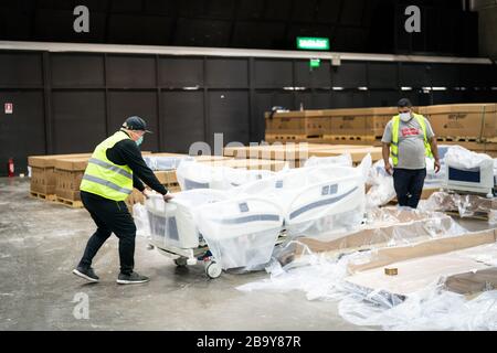 Santiago. März 2020. Die Arbeiter wickeln am 24. März 2020 Betten im Espacio Riesco Convention Center in Santiago, der Hauptstadt Chiles, aus. Das Zentrum wird in ein temporäres Krankenhaus für Patienten umgewandelt, die mit COVID-19 infiziert sind. Chile hatte 922 bestätigte Fälle von COVID-19 mit zwei Todesfällen, berichtete das Gesundheitsministerium am Dienstag. Kredit: Xinhua/Alamy Live News Stockfoto