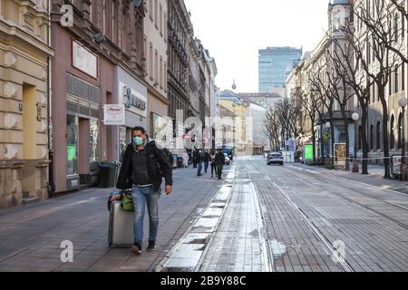 Zagreb, Kroatien - 22. März 2020: Tagsüber leere Straßen von Zagreb wegen des Corona-Virus. Tourist mit Maske und Tasche, die den Jurisic hinunter geht Stockfoto