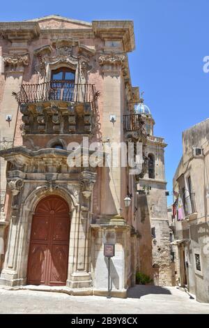 Eine kleine Straße zwischen den alten Häusern von Ragusa, einer sizilianischen Stadt, die als UNESCO-Weltkulturerbe anerkannt ist Stockfoto